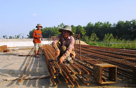 Nhà thầu đang đẩy nhanh tiến độ thi công cầu dân sinh tại thôn Triêm Nam. Ảnh: VĂN SỰ