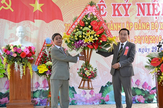 Phó Bí thư Thường trực Huyện ủy Đại Lộc - ông Nguyễn Công Thanh (đứng bên phải) tặng hoa chúc mừng Đảng bộ xã Đại Quang. Ảnh: CÔNG TÚ