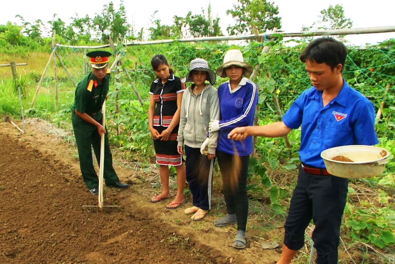 Các trí thức trẻ hướng dẫn đồng bào biên giới cách gieo trồng vườn rau sạch. Ảnh: T.A