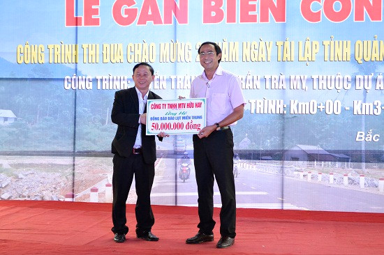 Giám đốc Công ty TNHH Một thành viên Hữu Hay - ông Trần Hay (đứng bên trái) trao tặng 50 triệu đồng ủng hộ đồng bào miền Trung bị ảnh hưởng do mưa lũ. Ảnh: CÔNG TÚ