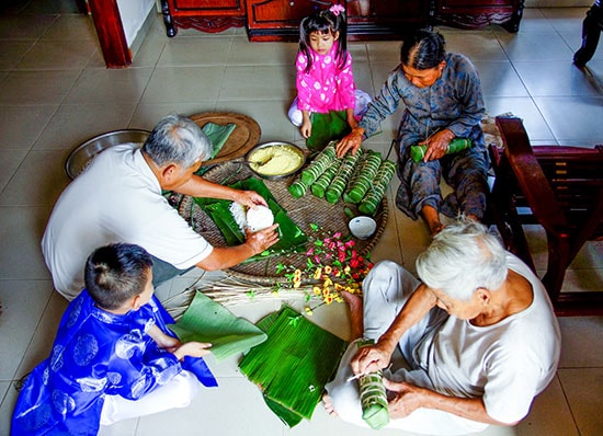 Ông bà, con cháu quây quần bên nhau gói bánh chuẩn bị cho ngày chạp mả. Ảnh: PHƯƠNG THẢO