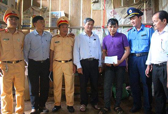 Ban An toàn giao thông tỉnh trao quà hỗ trợ cho gia đình Trần Văn Hận. Ảnh: VĂN HÀO