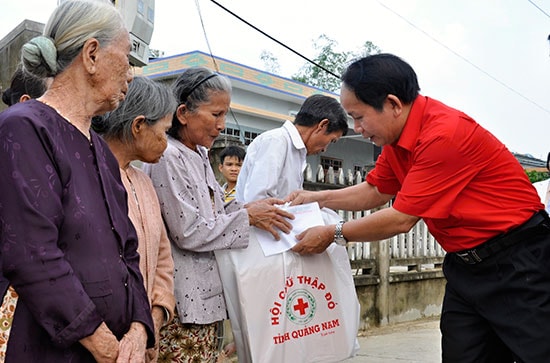 Ông Trương Văn Mười - Chủ tịch Hội CTĐ tỉnh tặng quà cho người nghèo. Ảnh: VINH ANH