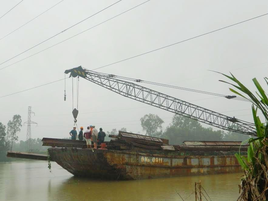 Đến chiều 1.12, lực lượng chức năng vẫn tìm cách đưa xà lan ra khỏi khu vực nguy hiểm.  