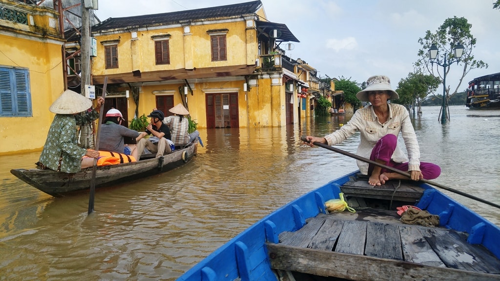 Chị Trần Thị Thưởng (bìa phải), 44 tuổi, nhà ở An Hội cho biết từ trưa ngày 3.12, khi nước lũ dâng ngập đường Bạch Đằng thị chị vào sát đường Nguyễn Thái Học để đón và chở khách đi dạo phố cổ bằng thuyền. Ảnh: XUÂN THỌ