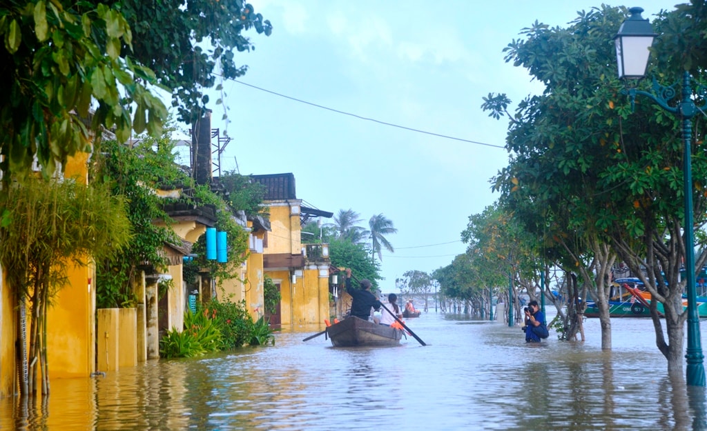 Không ít tay máy phải lội nước thế này để săn ảnh Hội An ngày lũ. Ảnh: XUÂN THỌ