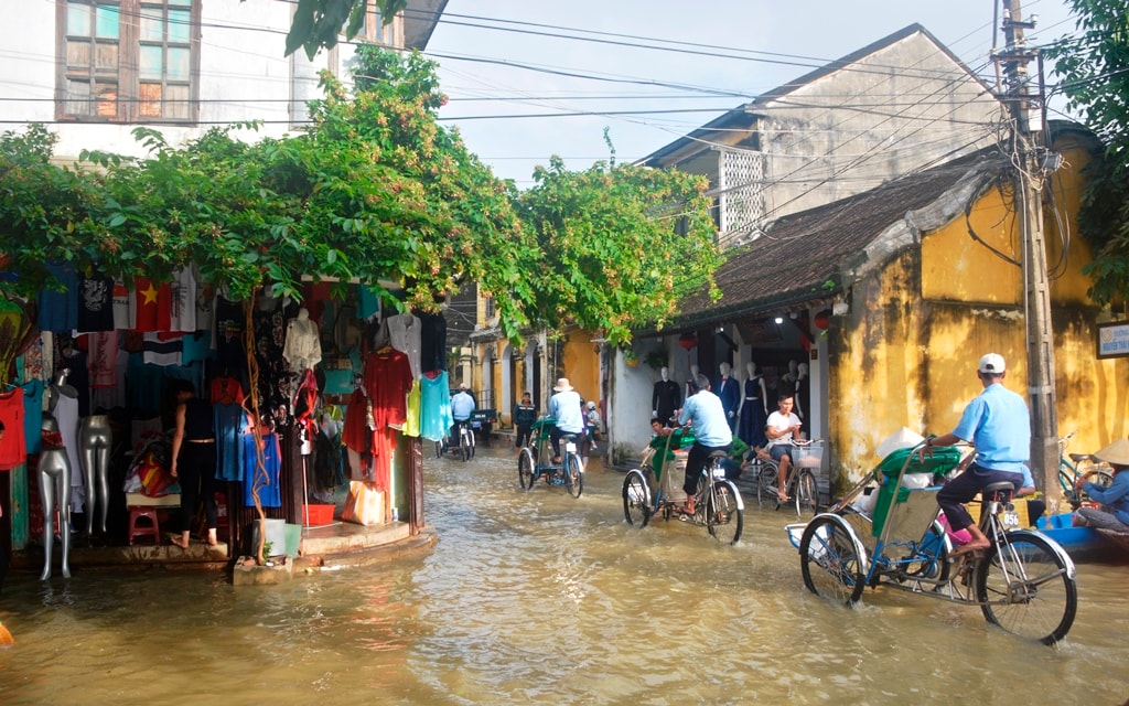 Còn đối với du khách, đôi khi ngồi xích lô dạo phố cổ ngày lũ cũng có thú riêng. Ảnh: XUÂN THỌ