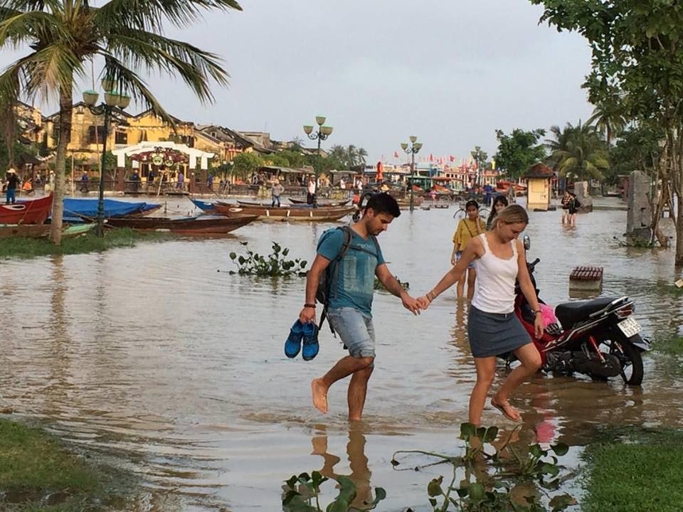 ... trong khi đó, đôi bạn thích thú xách dẹp lội lụt. Ảnh: QUỐC HẢI