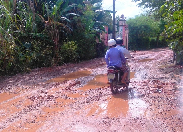 Người và phương tiện vất vả qua lại đoạn đường sình lầy như thời 30 năm trước. Ảnh: Triêu Nhan