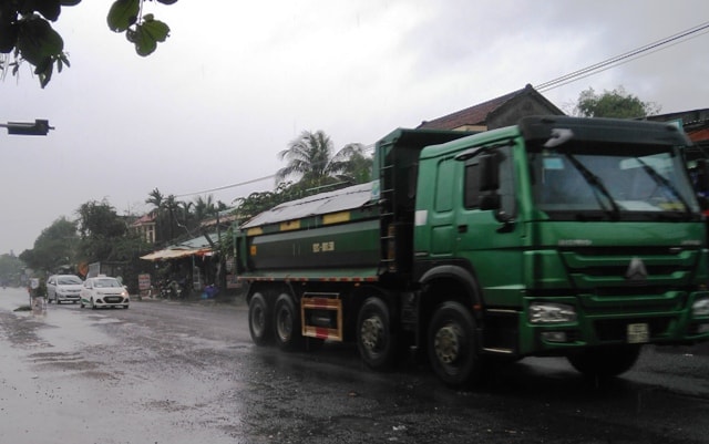 Bất chấp những ngày mưa lũ, tập đoàn xe tải chở vật liệu vẫn lao vun vút trên tuyến ĐT 609B về hướng Hòa Khương (Đà Nẵng). Ảnh: Triêu Nhan