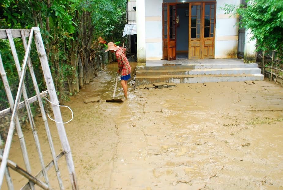 Người dân Đông Bình bắt đầu dọn lũ ngay khi nước rút Ảnh: HẢI NAM