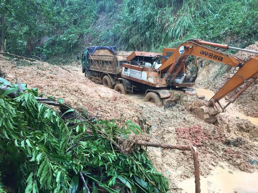 Hốt dọn đất đá, cây cối sạt xuống lòng đưòng. Ảnh: CÔNG TÚ