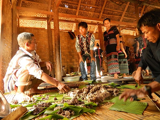 Trưởng thôn Pơrning (xã Lăng, Tây Giang) - Bh’nướch Lạc theo dõi việc chia thịt cho các hộ trong thôn.  Ảnh: BRIU QUÂN