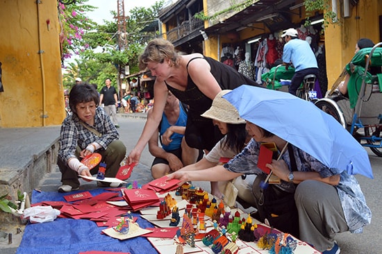 Du lịch Quảng Nam tuy tăng trưởng nhưng vẫn đối diện với nhiều thách thức. TRONG ẢNH: Bán hàng rong tự phát ở phố cổ Hội An. 