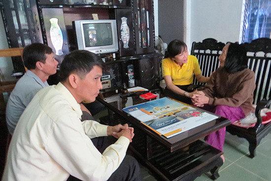 Nhân viên Bưu điện phường An Xuân (Tam Kỳ) đến tận nơi thăm hỏi, chi trả chế độ cho mẹ Hồ Thị Ngô (93 tuổi). Ảnh: B.L
