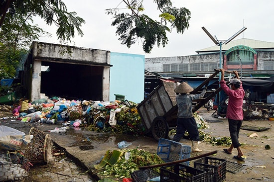 Rác tràn ra ngoài nhà chứa tại chợ Vĩnh Điện gây ô nhiễm môi trường xung quanh.Ảnh: VĨNH LỘC