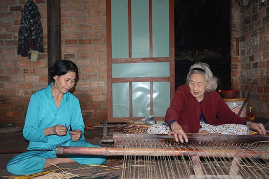 Những lao động lớn tuổi còn bám trụ với nghề dệt chiếu Bàn Thạch. Ảnh: H. BẰNG