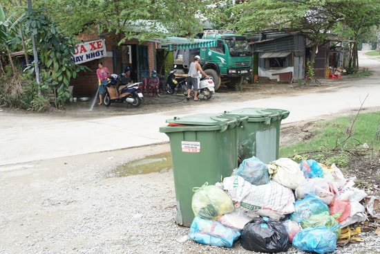 Hai thùng đựng rác đầy tràn ra ngoài làm mất mỹ quan đô thị và gây ô nhiễm môi trường.