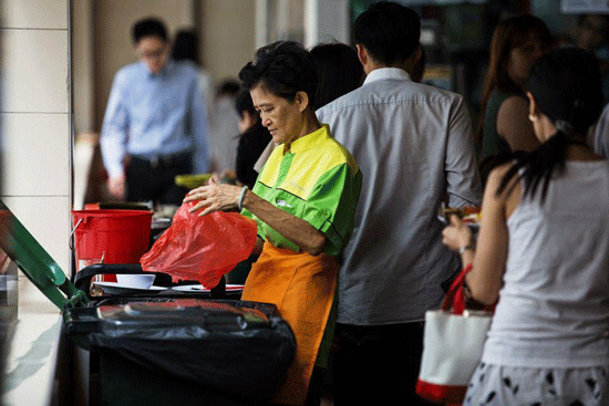 Bà Helen đang làm việc tại cửa hàng thực phẩm Raffles Place, Singapore. Ảnh: Bloomberg