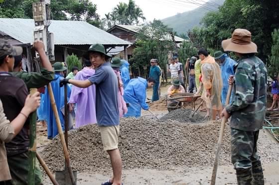 Các tình nguyện viên thuộc trường Đại học Bách khoa Đà Nẵng đổ sân bê tông giúp người dân. Ảnh: Q.T