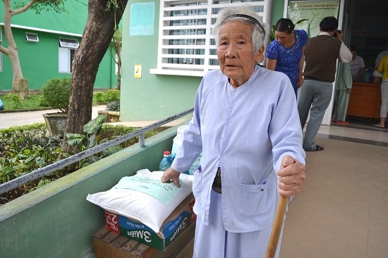 Bà Ngô Thị Quà bên suất quà mình vừa nhận. Ảnh: CT