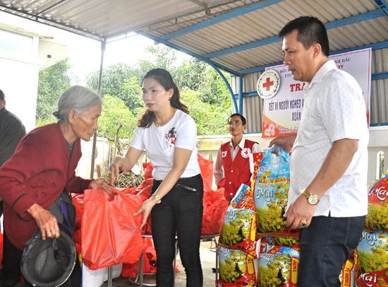 Vợ chồng anh Võ Đăng Trí tặng quà tết cho người nghèo xã Tam Anh Bắc. Ảnh: VINH ANH