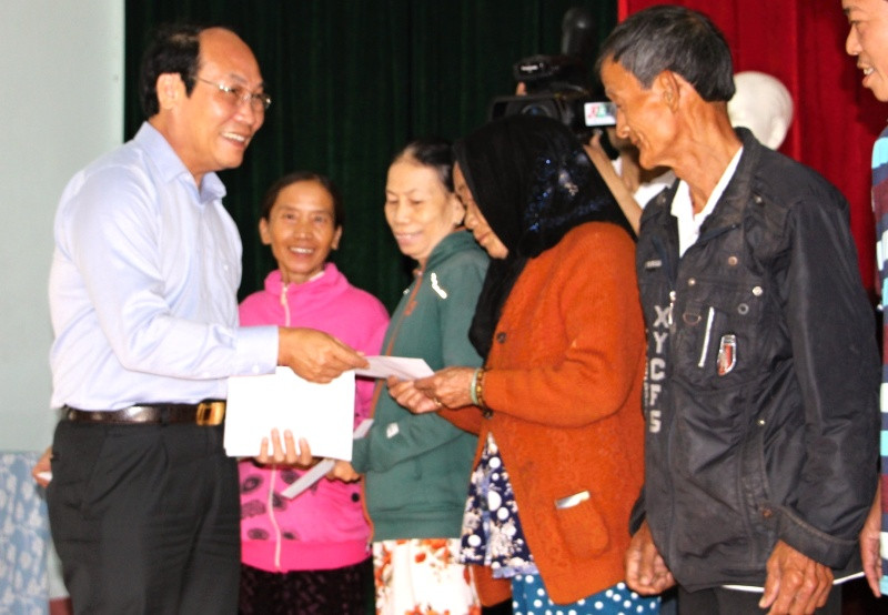 Chủ tịch Ủy ban MTTQ Việt Nam tỉnh Võ Xuân Ca tặng quà cho người dân vùng lũ. Ảnh: V.A