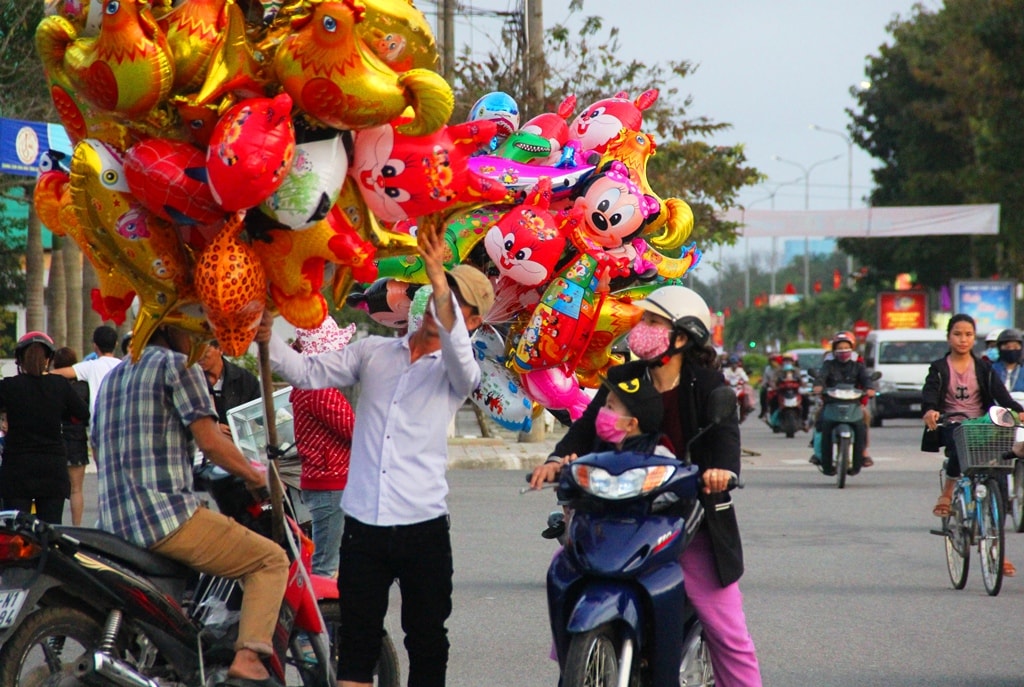 Tết, nhưng anh Lộc vẫn chào bán bóng bay cho khách đi đường từ 29 tháng Chạp. Ảnh: A.N