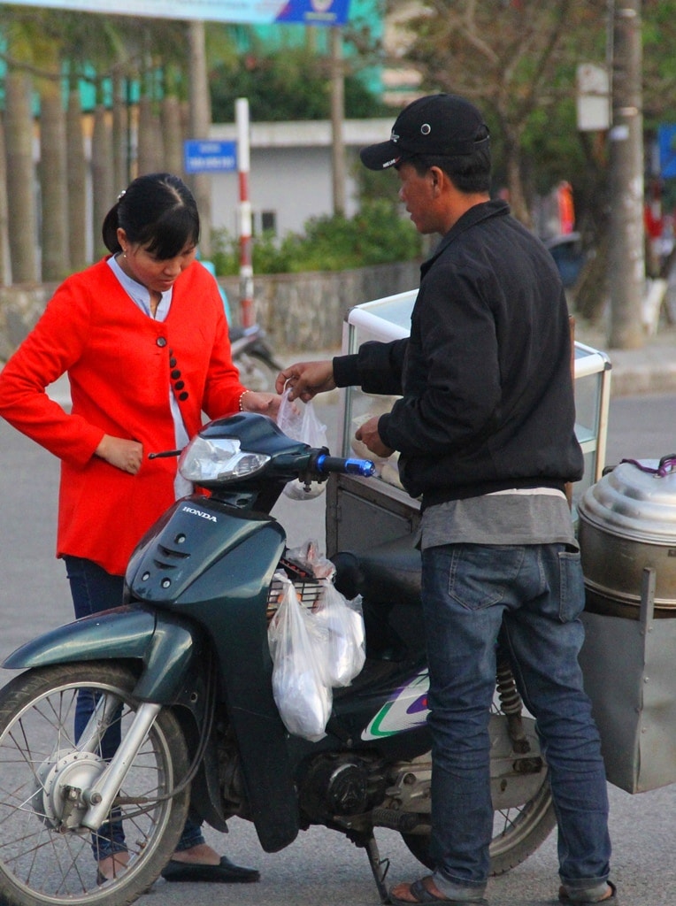 Sau nhiều vòng dạo bán, người đàn ông bán bánh bao nà may mắn mới có khách hỏi mua. Ảnh: A.N