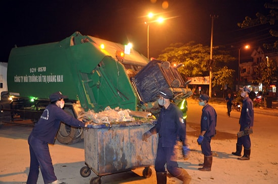 Công nhân chuyển rác lên xe chuyên dụng đem đi xử lý.Ảnh: TRẦN HỮU