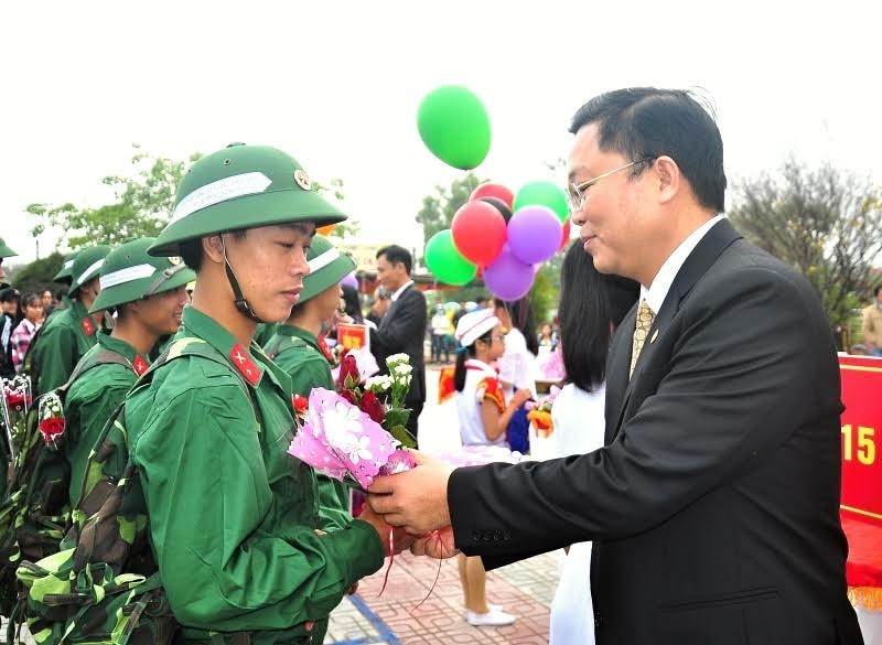 Phó Chủ tịch UBND tỉnh Lê Trí Thanh tặng hoa động viên thanh niên lên đường làm nhiệm vụ. Ảnh: VINH ANH