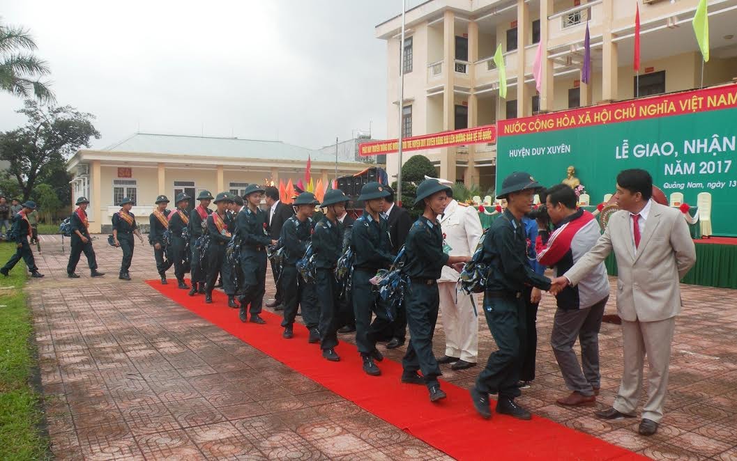 Lãnh đạo tỉnh và huyện Duy Xuyên bắt tay động viên các tân binh.  Ảnh: VĂN SỰ