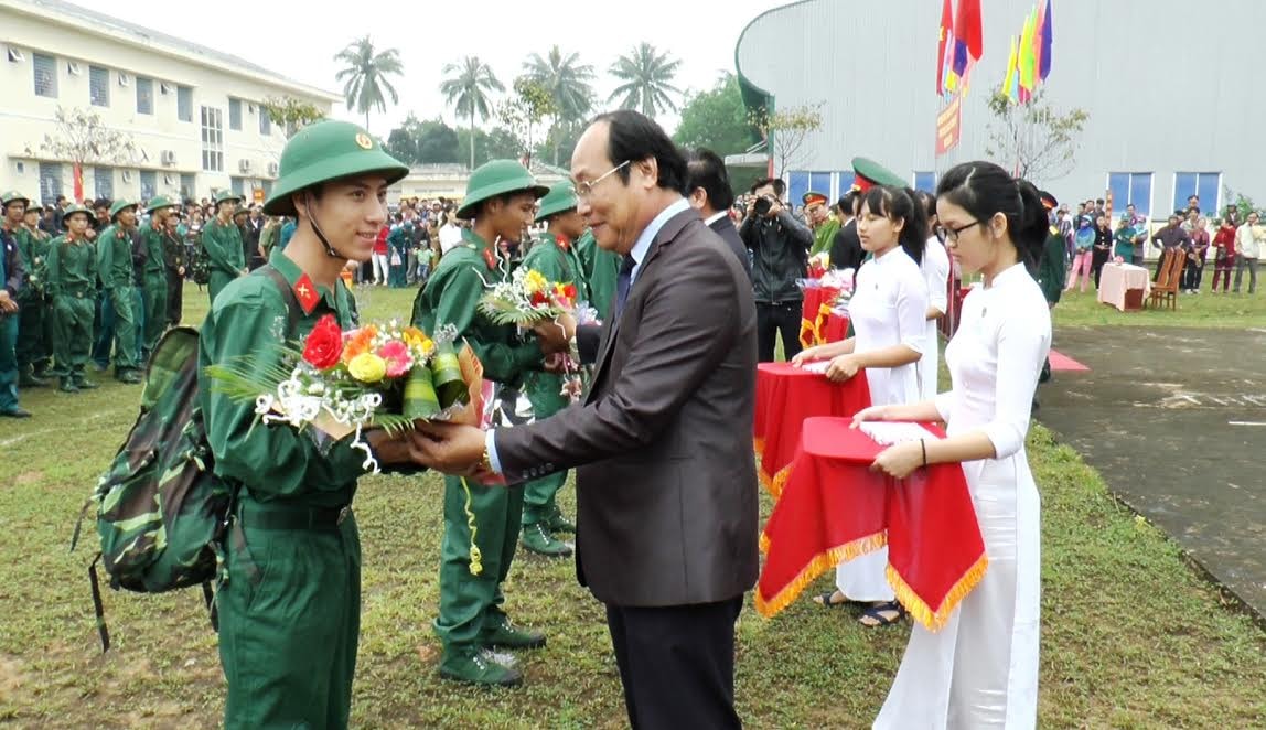 Đồng chí Võ Xuân Ca - Ủy viên Ban Thường vụ Tỉnh ủy, Chủ tịch Ủy ban MTTQ Việt Nam tỉnh tặng hoa động viên các tân binh huyện Quế Sơn.  Ảnh: NHI THÁI