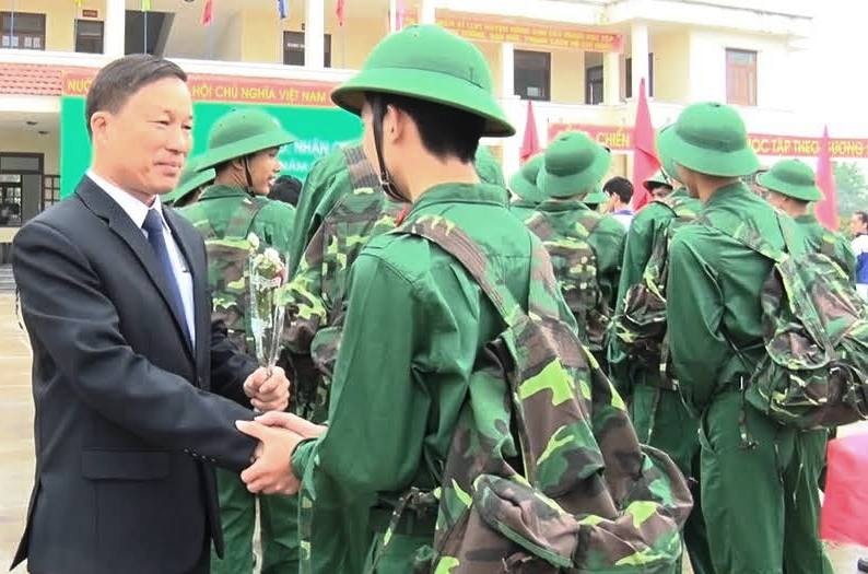 Chủ tịch UBND huyện Nông Sơn Lê Tấn Trung tặng hoa chúc mưng thanh niên trước lúc lên đường. Ảnh: THU PHƯƠNG