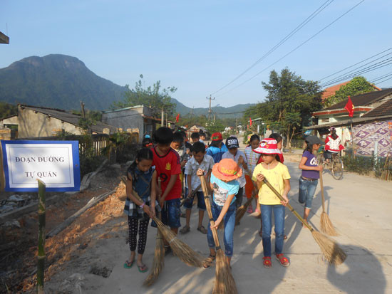 Các học sinh Trường Tiểu học Sơn Viên thay phiên nhau làm sạch “Đoạn đường tự quản”. Ảnh: H.Đ