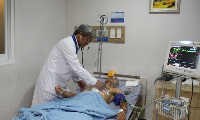 Bác sỹ Ngô Đức Đễ thăm khám cho bệnh nhân. (Ảnh: Lê Xuân/TTXVN)