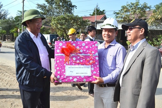 Chủ tịch Đinh Văn Thu tặng quà động viên nhà thầu thi công đường vào trung tâm du lịch phố cổ. Ảnh: CÔNG TÚ