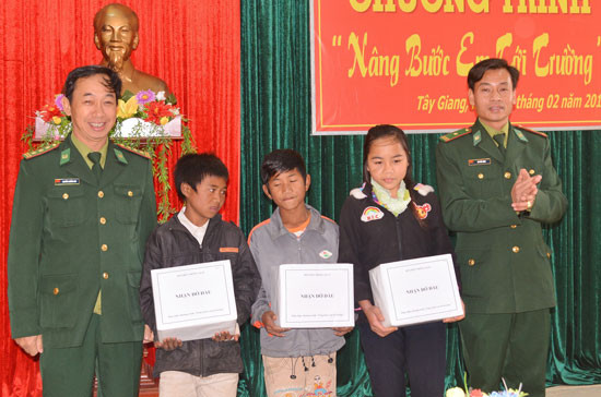 Cán bộ, chiến sĩ Đồn Biên phòng A Xan (Tây Giang) trao quà hỗ trợ  nhận đỡ đầu các em học sinh khó khăn. Ảnh: Đ.N