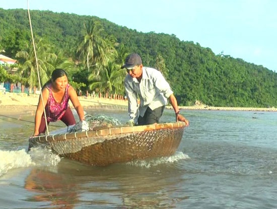 Chị Trần Thị Mai thôn Bãi Hương xã Tân Hiệp (TP Hội An) khiêng ngư cụ và đi biển cùng chồng. Ảnh: L.H