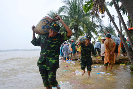 Cán bộ, chiến sĩ thuộc Bộ CHQS tỉnh tham gia đắp kè bờ biển, ứng phó với bão lũ. 