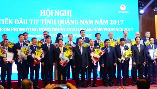 Thủ tướng Nguyễn Xuân Phúc và lãnh đạo tỉnh chụp hình lưu niệm cùng các doanh nghiệp được trao chứng nhận đăng ký đầu tư tại hội nghị “Xúc tiến đầu tư tỉnh Quảng Nam năm 2017”. Ảnh: PHƯƠNG THẢO