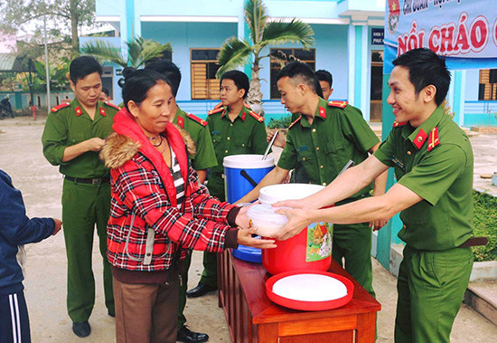 Các chiến sĩ Công an huyện Đông Giang trao từng suất cháo cho người bệnh, cùng hưởng ứng Tháng thanh niên 2017. Ảnh: Đ.N
