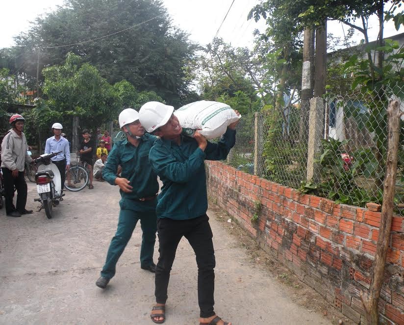 Vác bao tải cát chần mái tôn nhà của những hộ dân già yếu, neo đơn.