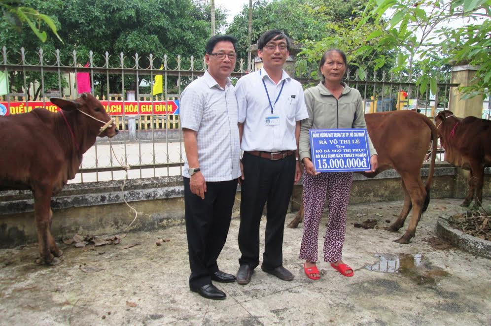 Đại diện Hội đồng hương xã Duy Trinh tại TP. Hồ Chí Minh và lãnh đạo địa phương trao bò cho những hộ nghèo.
