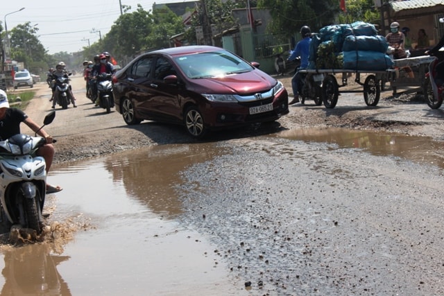 Sự chênh về độ cao nền đường giữa đoạn đã được sửa chữa và đoạn đường cũ khiến các phương tiện vô cùng khổ sở, vất vả khi lưu thông. Ảnh: TRIÊU NHAN