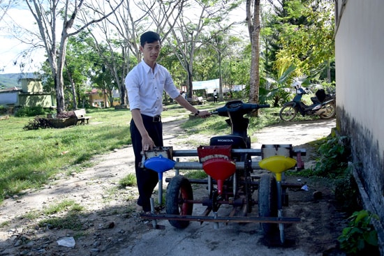 Em Nguyễn Quốc Toàn bên chiếc máy gieo hạt kết hợp.  Ảnh: THẮNG DƯƠNG