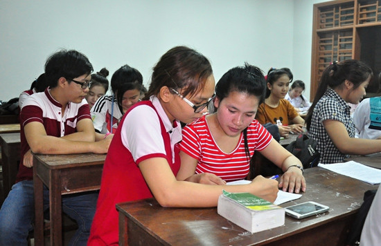 Thanh viên Câu lạc bộ Tiếng Việt giúp đỡ các bạn sinh viên Lào học tiếng Việt. Ảnh: VINH ANH