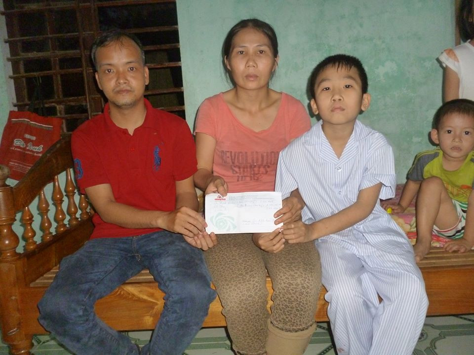 Tác giả bài viết trao tiền cho gia đình cháu Trương Văn Bảo. ảnh: C.N