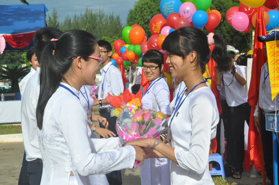 Học sinh lớp 12 tặng hoa chúc mừng học sinh lớp 10 vừa trúng tuyển vào trường tại lễ khai giảng năm học mới của Trường THPT chuyên Nguyễn Bỉnh Khiêm. Ảnh: XUÂN PHÚ