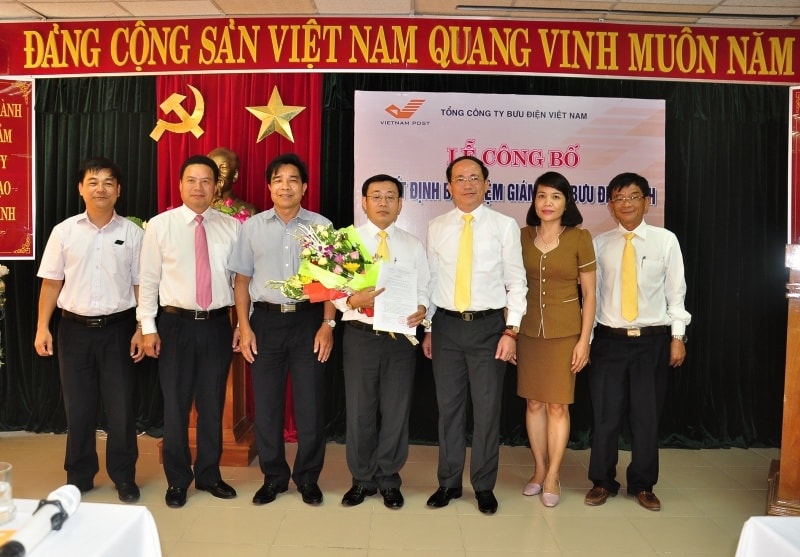 Các đồng chí lãnh đạo tỉnh, Tổng Công ty Bưu điện Việt Nam tặng hoa chúc mừng ông Trần Việt Hùng. Ảnh: VINH ANH